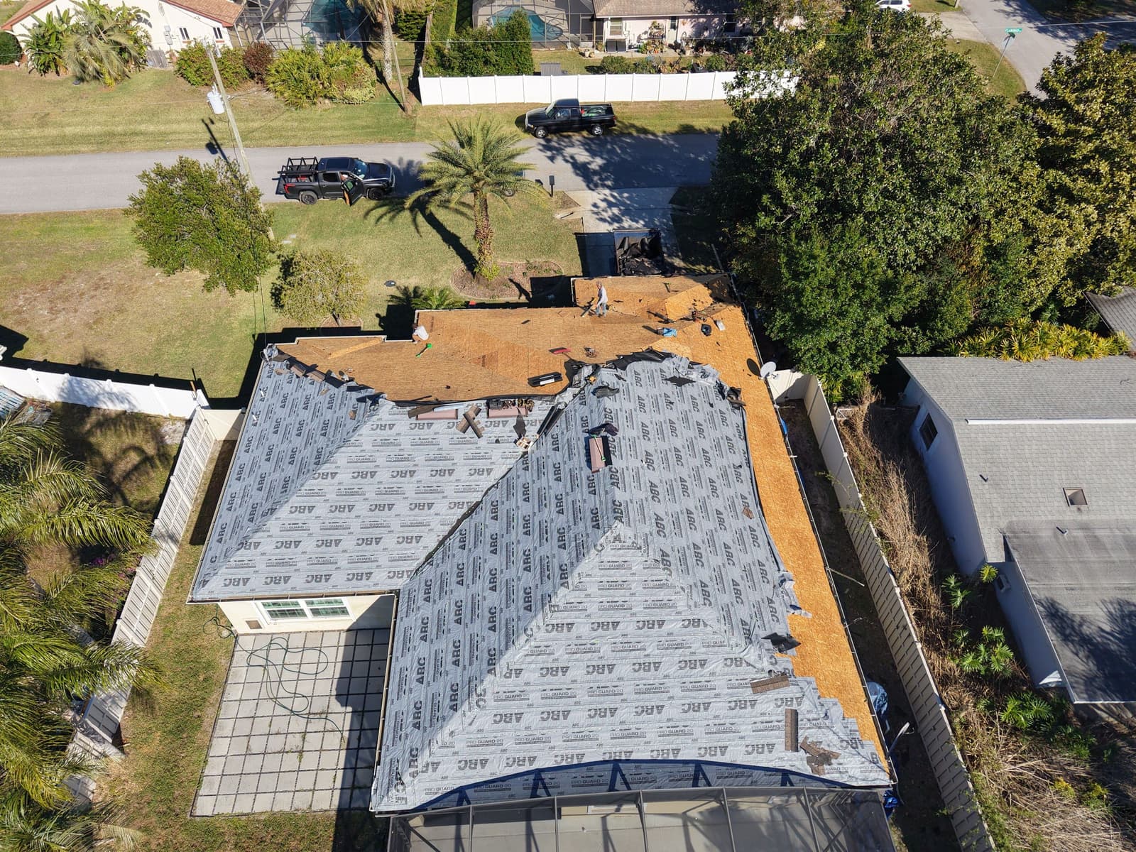Drone view of a Palm Coast home mid-replacement, old roof torn off to bare decking with new underlayment going on